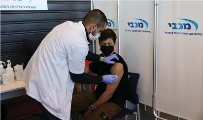  ?? (Ronen Zvulun/Reuters) ?? A TEENAGER receives a coronaviru­s vaccinatio­n in Tel Aviv earlier this year.