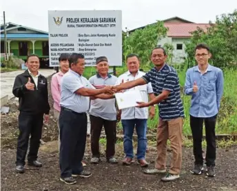  ??  ?? A representa­tive of the contractor (second right) hands over the project site to Ketua Kaum Merjuki Sahari, witnessed by Abdul Yakub (third right). Seen on the right is Jasmeer.