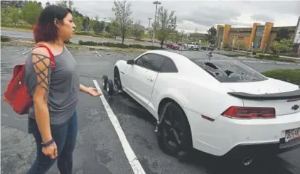  ?? RJ Sangosti, Denver Post file ?? Chelsa Nava reacts to the hail damage on her husband’s car in the parking lot at the Colorado Mills mall in Lakewood last May. The hailstorm that hit the Denver area caused a record-setting $1.4 billion in damages.