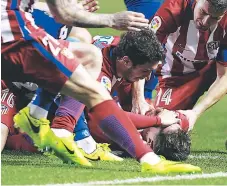  ??  ?? ASISTENCIA. Los jugadores del Atlético asisten al delantero rojiblanco Fernando Torres tras sufrir un golpe.