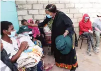  ?? ?? First Lady Dr Auxillia Mnangagwa puts a hat on T anyaradzwa Mugeyi during her visit in Mabvuku on Monday