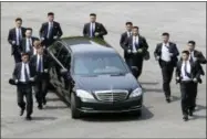  ?? KOREA SUMMIT PRESS POOL VIA AP ?? North Korean security personnel run by the car carrying North Korean leader Kim Jong Un, returning to the North for a lunch break Friday after a morning session of the summit with South Korean President Moon Jae-in at the border village of Panmunjom in...