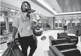  ?? AMY DAVIS/BALTIMORE SUN ?? Michael Pierce remains upbeat as the Ravens players clean out their lockers after their loss to the Titans on Saturday night.