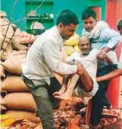  ?? AFP ?? A man is carried from the debris of his damaged home following a major dust storm in Etmadpur, Agra district.