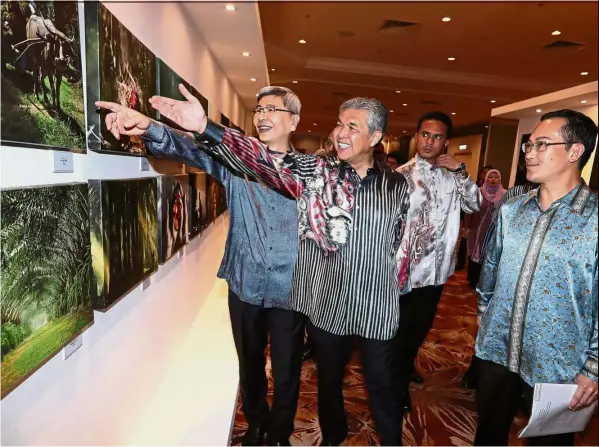  ??  ?? Great progress
Deputy Prime Minister Datuk Seri Dr Ahmad Zahid Hamidi (centre) visiting a palm oil photo exhibition. With him are Plantation Industries and Commoditie­s Minister Datuk Seri Mah Siew Keong (left) and Malaysian Palm Oil Council chairman...