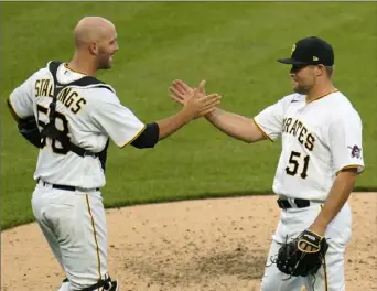  ??  ?? Reliever David Bednar and catcher Jacob Stallings meet on the mound after the final out of the Pirates’ 7-1 win.