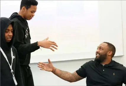  ?? Sebastian Foltz/Post-Gazette photos ?? Steel Valley High School student Ricardo Scott, 15, greets social justice and police relations activist Leon Ford during the Woodland Hills Student Summit Friday at Penn State Greater Allegheny Campus in McKeesport. Mr. Ford was paralyzed in a police-involved shooting and now works to address community police relations.