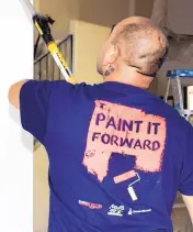  ??  ?? Conrad Lujan of Mike’s Quality Paints puts a fresh coat of paint on the walls at the home of Kym and David Thurman, winner of this year’s Paint It Forward.