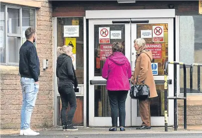  ??  ?? Queues outside health centres before they open as people try to get an appointmen­t.