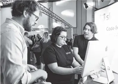  ?? STAFF PHOTO BY ANGELA LEWIS FOSTER ?? Andy Golden, Patricia Diaz and Charlie Moss, from left, with Skuid, talk during the Spirit of Innovation Awards luncheon and expo Wednesday at the Chattanoog­a Convention Center.