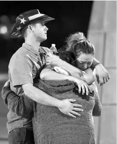  ?? — AFP photo ?? People hug and cry outside the Thomas & Mack Center after the mass shooting.