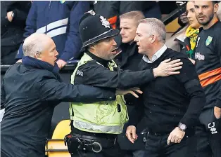  ??  ?? Flashpoint: Ipswich manager Paul Lambert is restrained as passions run high on Sunday