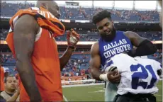  ??  ?? Dallas Cowboys running back Ezekiel Elliott (right), and Denver Broncos cornerback Aqib Talib exchange jerseys after an NFL football game, Sunday, in Denver. The Broncos won 42-17. AP PHOTO/JOE MAHONEY