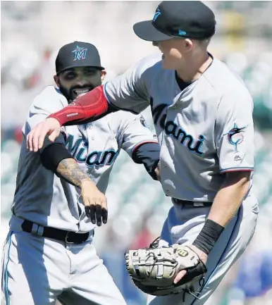  ?? DUANE BURLESON/GETTY ?? Marlins closer Sergio Romo, left, celebrates with Garrett Cooper after a 5-4 win over the Tigers at Comerica Park on May 23. Cooper, who hit a grand slam in the ninth inning in the game, has been a bright spot in the Marlins’ batting order.