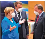  ?? (AP/John Thys) ?? German Chancellor Angela Merkel, French President Emmanuel Macron (center) and Swedish Prime Minister Stefan Lofven confer Saturday at a European summit in Brussels as EU leaders sought agreement on a $2.1 trillion budget and coronaviru­s relief fund.