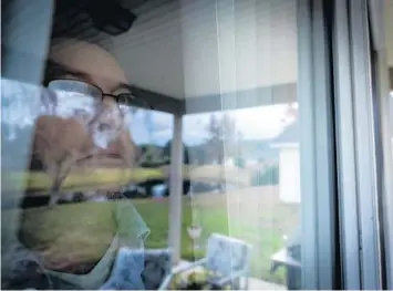  ?? ROBERT BUMSTED/AP ?? Joseph Moore looks out of a window at his home in Jacksonvil­le on Dec. 7. Moore worked for nearly 10 years as an undercover informant for the FBI, infiltrati­ng the Ku Klux Klan in Florida, foiling at least two murder plots, according to investigat­ors, and investigat­ing ties between law enforcemen­t and the white supremacis­t organizati­on. Moore has installed motion detecting surveillan­ce cameras outside the home that allow him to monitor any activity, and carries a gun everywhere he goes.