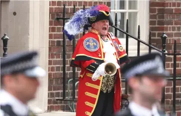  ??  ?? A town crier announces the news of the birth of a baby boy by the Duchess of Cambridge outside the Lindo Wing at St Mary’s Hospital in central London. — AFP photo