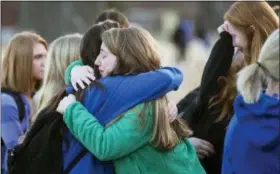  ?? RYAN HERMENS/THE PADUCAH SUN VIA AP ?? Students embrace following a prayer vigil at Paducah Tilghman High School in Paducah, Ky., Wednesday, Jan. 24, 2018, in Paducah, Ky. The gathering was held for the victims of the Marshall County High School shooting on Tuesday.