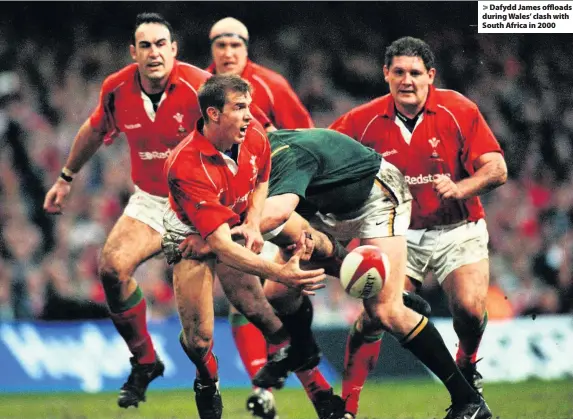  ??  ?? &gt; Dafydd James offloads during Wales’ clash with South Africa in 2000