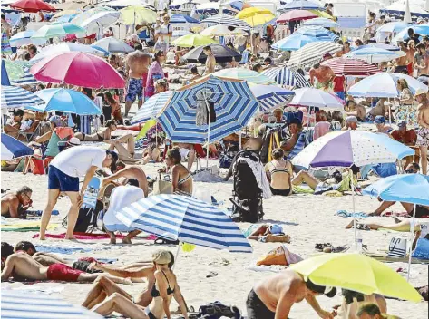  ?? REUTERS ?? People enjoy a sunny and warm weather on the beach of the Croisette amid the coronaviru­s outbreak in Cannes, France yesterday.