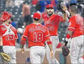  ?? Jeffrey McWhorter Associated Press ?? ANGELS RELIEF PITCHER Blake Parker (53) is congratula­ted by his teammates last season after a win in Texas. Parker’s ERA this spring is 18.69.