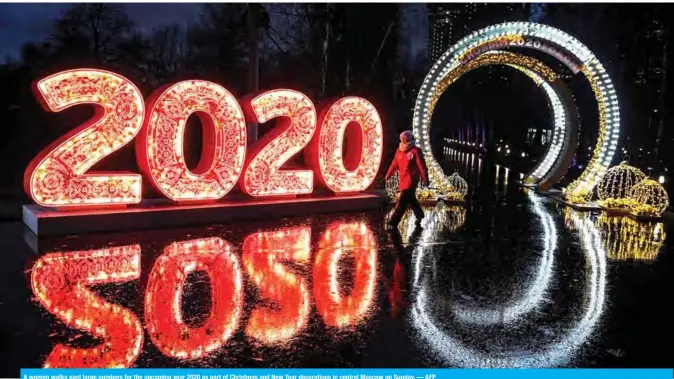  ??  ?? A woman walks past large numbers for the upcoming year 2020 as part of Christmas and New Year decoration­s in central Moscow on Sunday. — AFP