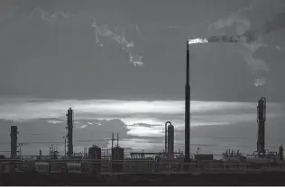  ?? Jon Shapley / Staff file photo ?? Natural gas is flared as the sun sets behind a processing plant near Eunice, N.M., in 2019.