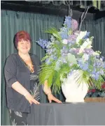  ??  ?? ●● Visiting demonstrat­or Jane Pugh (left) with one of her arrangemen­ts and Prestbury Flower Club ‘garden snippets’ winner Jackie Burns