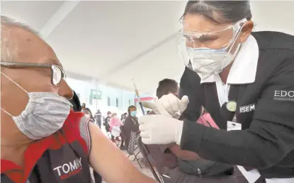  ??  ?? Una enfermera muestra a la persona la jeringa con la dosis antes de inyectarla, durante la jornada de vacunación de ayer en el Estado de México.