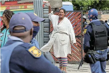  ?? /Reuters ?? Live wire: A resident shouts at police officers at Oasis Farm informal settlement in Philippi, Cape Town, during a clampdown on illegal electricit­y connection­s in the area on Tuesday.