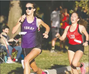  ?? DAVID WITTE/NEWS-SENTINEL ?? Tokay's Kali Anema passes Lodi's Yasmin Melendrez for second place down the stretch at the TCAL Championsh­ips on Wednesday at Lodi Lake Park. Below: Lodi teammates Pamela Decko, right, and Carlee McCabe battle for fourth place.