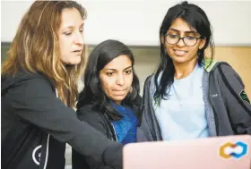  ?? Nicole Boliaux / The Chronicle ?? Mentor Ricky Trigalo (left) works on a presentati­on with Rakshitha Bhat and Akanksha Bindal at the CodeHouse event for female college students in tech.