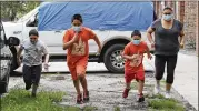  ?? AP ?? Chicago Run at-home programs are an essential part of Mariana Ochoa’s family routine as she runs Friday with her sons Victor (from left), 7, Mariano, 9, and Jesus, 5.