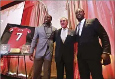  ??  ?? Atlanta Falcons owner Arthur Blank (center) honors former Falcons quarterbac­k Michael Vick (right) and wide receiver Roddy White as they officially retire from the NFL on Monday in Atlanta. AP PHOTO
