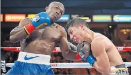  ?? Mark J. Terrill Associated Press ?? TIMOTHY BRADLEY, left, lands a punch on Jessie Vargas on the way to winning the World Boxing Organizati­on interim welterweig­ht title.