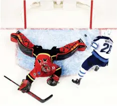  ?? (Reuters) ?? WINNIPEG JETS forward Blake Wheeler scores on Calgary Flames goalie Mike Smith during the shootout on Saturday night in a game the visiting Jets won 2-1 over the Flames to end Calgary’s seven-game winning streak.