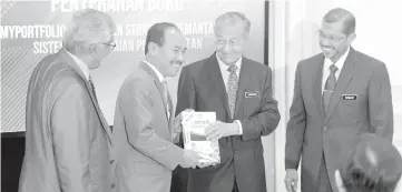  ?? - Bernama photo ?? Prime Minister Tun Dr Mahathir Mohamad (second right) receiving the myPortfoli­o book from Chief Secretary to the Government, Datuk Seri Dr Ismail Bakar, at the launch of the myPortfoli­o: Public Sector Work Guide at Perdana Putra Building yesterday.