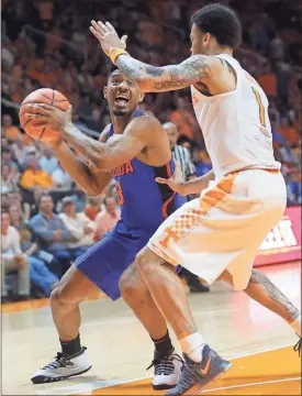  ?? Crystal LoGiudice / AP ?? Florida’s Jalen Hudson (left) is defended by Tennessee’s Lamonte Turner. The Gators have lost three games in a row and will host No. 12 Auburn tonight.