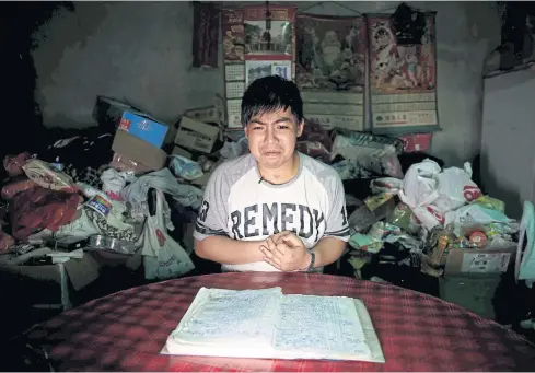  ??  ?? Chen Hong-zhi, 26, who suffers from severe short-term memory loss, consults his notes to recall what he did in the previous week at his home, in Hsinchu, Taiwan.