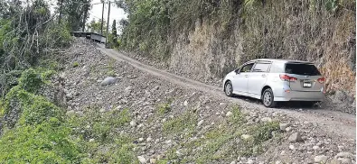  ?? PHOTOS BY CARL GILCHRIST ?? A motorist carefully navigating the breakaway along the Governor’s Pen road in St Mary.