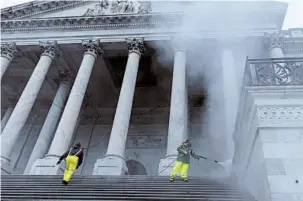  ?? ALEX EDELMAN/GETTY-AFP ?? Workers pressure-wash the steps of the U.S. Capitol in preparatio­n for President George H.W. Bush’s funeral.