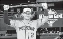  ?? Rob Carr / Getty Images ?? Bregman shows off the MVP trophy that he earned after hitting the go-ahead home run for the American League.