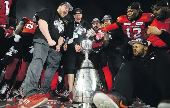  ?? DAVID BLOOM ?? The Calgary Stampeders fill the Grey Cup with beer as they celebrate their 27-16 Grey Cup win over the Ottawa Redblacks at Commonweal­th Stadium in Edmonton Sunday.