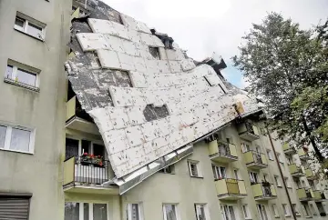  ??  ?? A roof destroyed by a storm hangs from an apartment building in Bydgoszcz, Poland. — Reuters photo