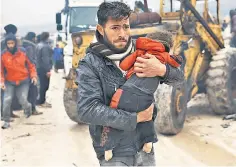  ?? ?? A man carries a quake victim in the Syrian village of Besnia near the Turkish border