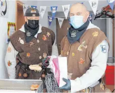  ?? FOTO: STEIDLE ?? Tim Lang und Andy Weber am Sonntagvor­mittag beim Verkauf der „Fasnetskia­chla“und „Schaumkuss­wegga“vor dem Vereinshei­m der IGF.