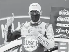  ?? BRYNN ANDERSON/AP ?? Kevin Harvick, wearing a mask, celebrates after winning Sunday at Darlington Raceway.