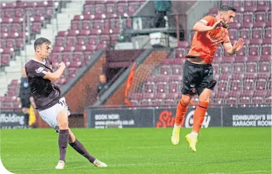  ??  ?? Andy Irving fires home from the edge of the area to equalise for Hearts, despite the efforts of Dundee United’s Nicky Clark to block the shot