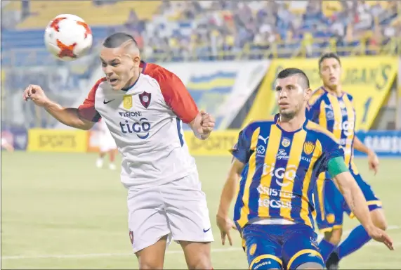  ??  ?? El volante azulgrana Jorge Rojas cabecea el balón ante la marca del luqueño Rubén Monges.