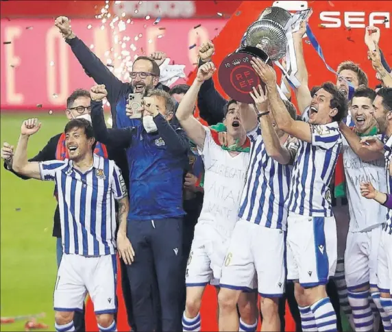  ??  ?? Los jugadores de la Real, eufóricos, levantan la Copa y celebran el título sobre el césped de La Cartuja.